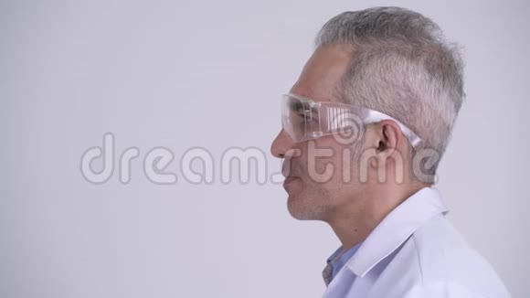 快乐的波斯男子医生戴着防护眼镜的侧写视图视频的预览图