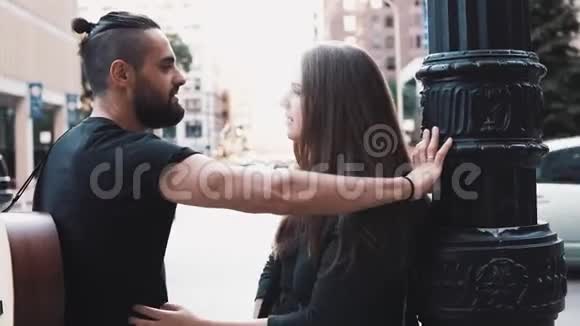男人带着吉他女孩在街上调情浪漫的高加索夫妇在街上微笑着交谈微笑着快乐4K视频的预览图