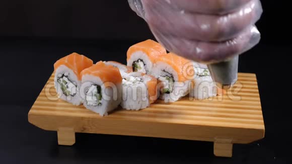 食物录像慢运动食品概念专业厨师的特写用寿司卷在木盘上浇芥末视频的预览图