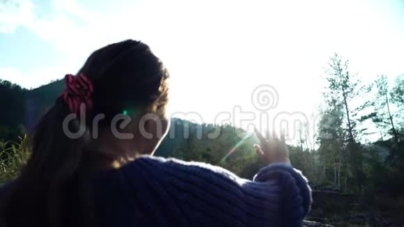 穿毛衣的女孩用手看太阳背面视频的预览图