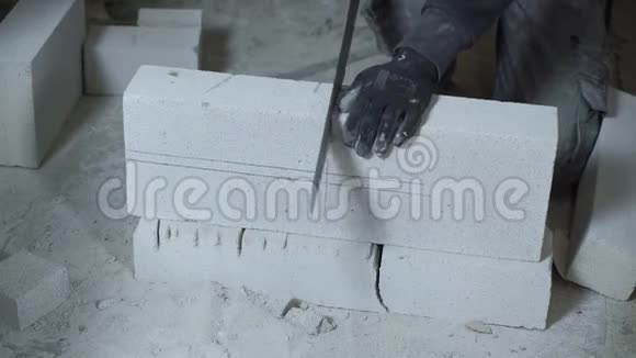 施工工人按标记锯加气混凝土砌块的特写视频的预览图