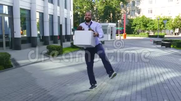 辞退观念招聘一名雇员带着纸板箱在办公楼之间行走视频的预览图