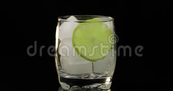 一种清爽的饮料被倒入一个装有冰块和石灰的玻璃杯中视频的预览图