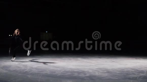 穿着黑色西装轮廓光线优美的溜冰者加速并突然停止冰鞋上的飞沙视频的预览图