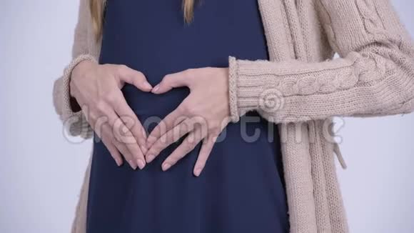 年轻快乐的孕妇腹部有心脏手势视频的预览图