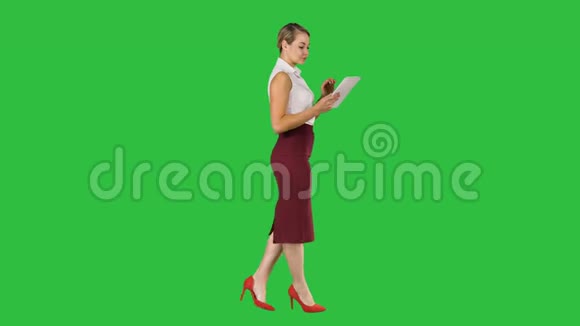 女商人使用电子标签行走在绿色屏幕铬键视频的预览图