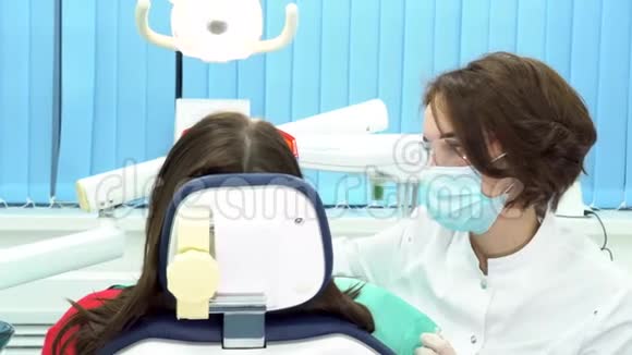 坐在牙科椅上接受牙医注射的女性患者的后视镜媒体做牙医的女人视频的预览图