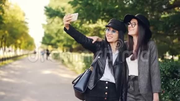 快乐的年轻女士购物狂正在街上自拍拿着袋子做着有趣的脸女人穿着视频的预览图