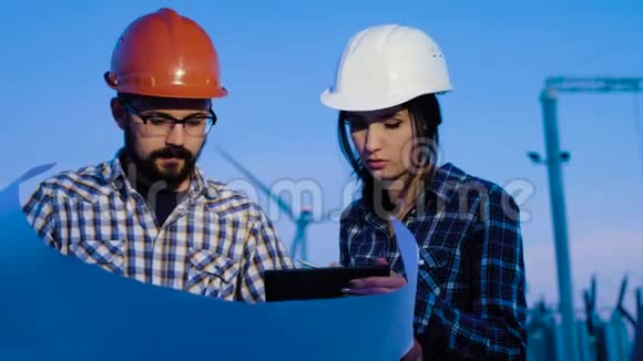 一个女人和一个男人两个工程师在一张大纸上做计算环顾四周检查信息视频的预览图
