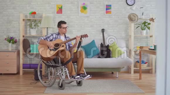 坐轮椅的年轻残疾人音乐家弹吉他视频的预览图