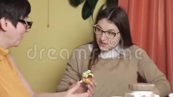 母亲吃蛋糕女儿喝咖啡厨房笑声谈话戴眼镜的妇女视频的预览图