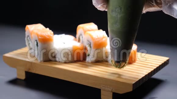 食物录像慢运动食品概念专业厨师的特写用寿司卷在木盘上浇芥末视频的预览图