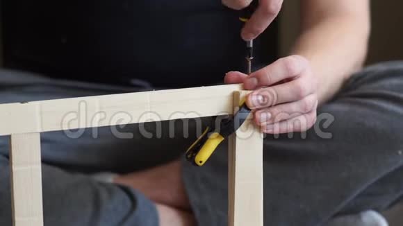 年轻的木匠用螺丝刀做木头的杂工视频的预览图