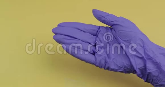 穿着蓝色医用手套的手把一个椭圆形的白色药丸放进另一只手视频的预览图