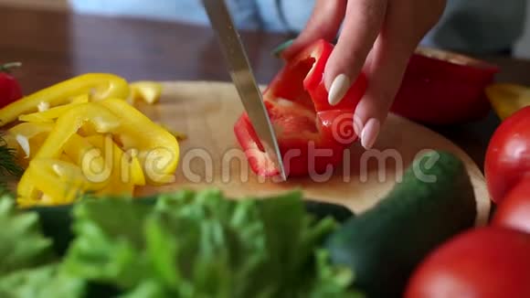 一个女人在木板上切成熟多汁的红椒的特写镜头视频的预览图