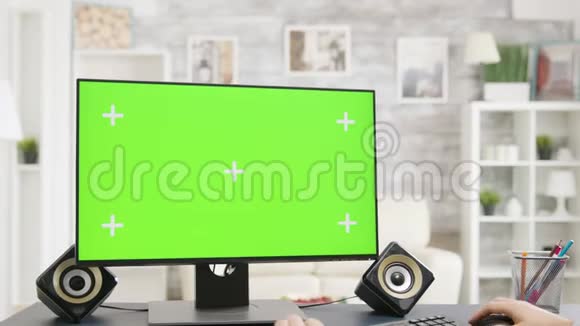 在明亮的房子里男人在工作在绿色屏幕上隔离PC视频的预览图