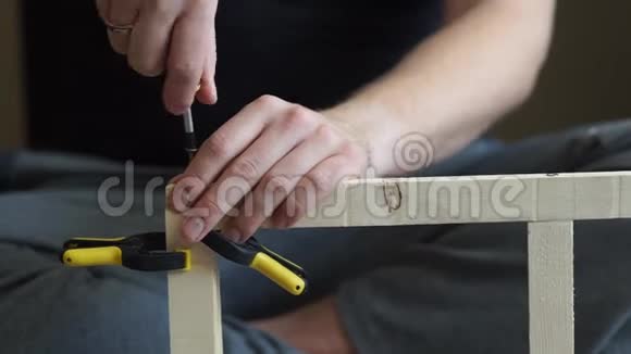 年轻的木匠用螺丝刀做木头的杂工视频的预览图