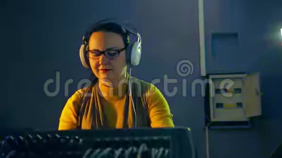 收音机里戴着耳机和眼镜的女DJ在混合控制台拿着迪斯科视频的预览图