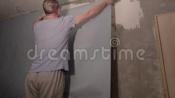一个人把墙纸粘在墙上视频的预览图