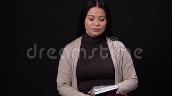 愤怒的亚洲女性手里拿着记事本视频的预览图