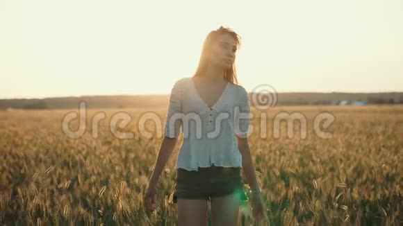 落日时分忧郁的女孩独自走在金色的麦田上视频的预览图