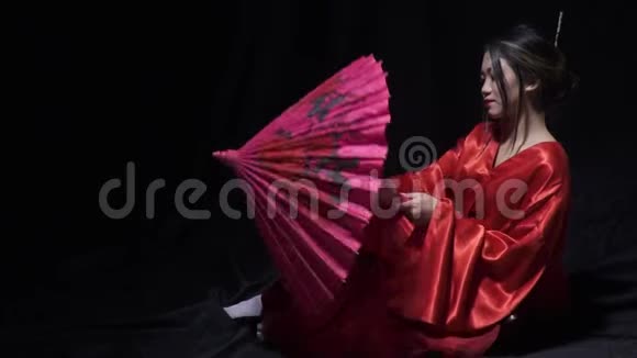 害羞的亚洲女士坐在地板上打开一把伞视频的预览图