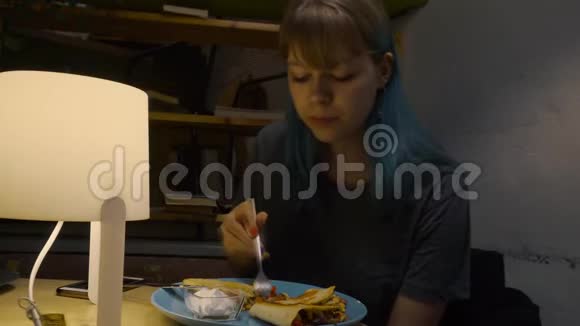 有着五颜六色头发的少女在咖啡馆里吃着美味的素食视频的预览图