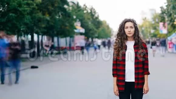 夏天一个年轻的邦联女子独自站在街上一边看着摄像机她的肖像画视频的预览图