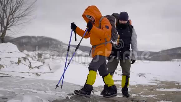 两个人去冬季远足朋友们有专业的设备他们沿着悬崖走视频的预览图