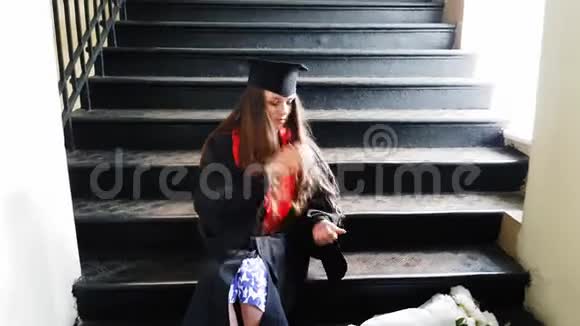 在大学里一位漂亮的学生硕士在坐在金属台阶上时用橡皮泥给她的腿贴上带子视频的预览图