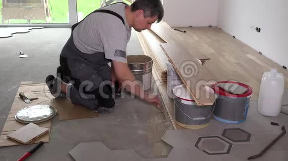 工人在地板上涂胶粘剂用于铺设地板视频的预览图
