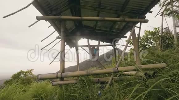 体育男子挂在木制横梁上做腹肌训练热带自然景观健身男子训练腹肌和核心视频的预览图