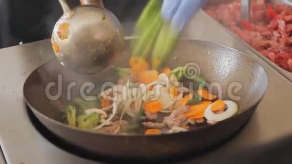 专业厨师在街头美食节炒菜炒肉用牛肉和蔬菜炒熟视频的预览图