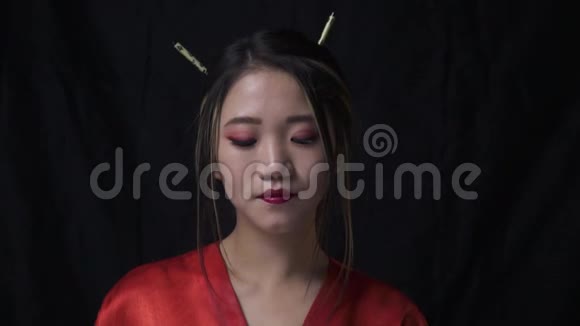 日本艺妓拿着筷子站在黑色的背景上着视频的预览图