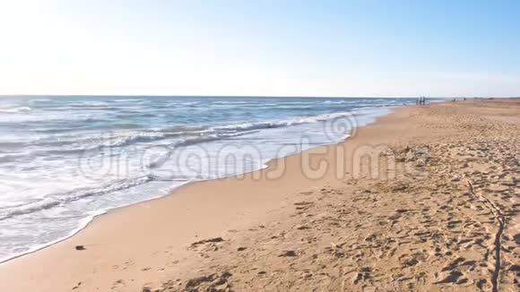 女人正在沙滩上慢跑美丽的波浪后景视频的预览图
