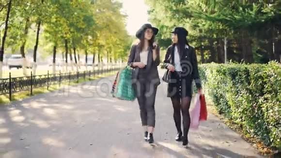 多莉拍了一张快乐女孩的照片购物狂们拿着购物袋在街上走来走去谈论新的话题视频的预览图