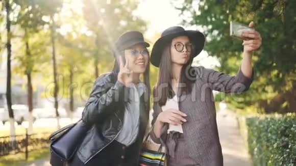 无人照顾的女孩正在使用智能手机自拍在街上摆着购物袋穿着时尚的衣服视频的预览图