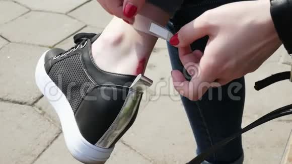 女孩在伤口上涂了石膏从运动鞋上揉了揉腿视频的预览图
