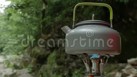 营地燃气燃烧器在大自然中煮茶视频的预览图