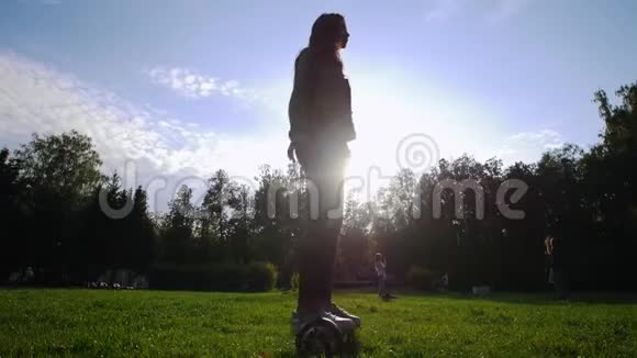 可怜的女孩骑着陀螺在草地上她在盘旋阳光灿烂视频的预览图