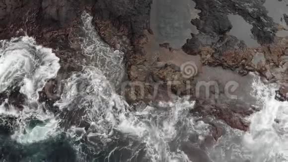 上景天然水池陡峭的火山岸冰封的火山熔岩的礁石风暴的海洋巨大的白色泡沫视频的预览图
