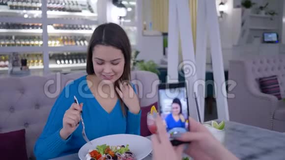 素食女性在健康晚餐期间在智能手机上为社交网络拍摄有用食物的肖像视频的预览图