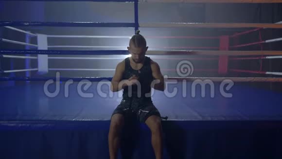 肌肉摔跤手在拳击比赛前用黑色绷带卷起来视频的预览图