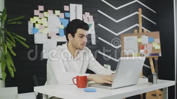 英俊的商人在电脑上打字写下一些东西视频的预览图