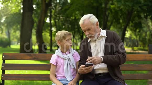 男孩教爷爷使用智能手机新技术对养老金领取者来说是困难的视频的预览图