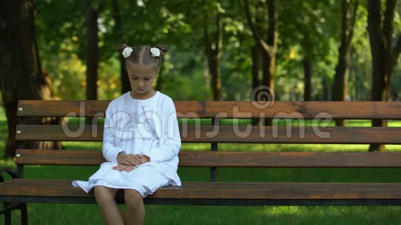 悲伤的女孩孤独地坐在长凳上等未来的父母来孤儿视频的预览图