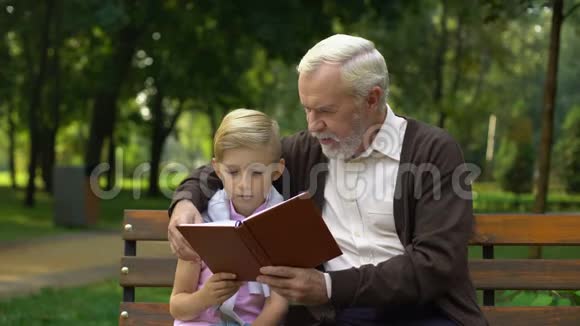 祖父和孙子在讨论书本在一起学习教育视频的预览图
