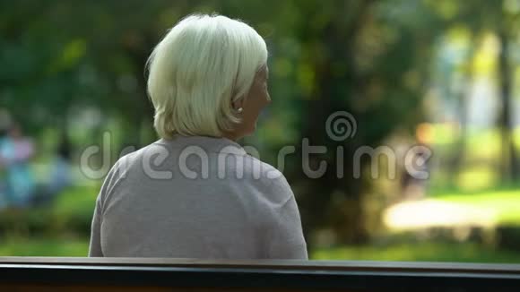 女孩拥抱坐在长凳上的奶奶真诚地爱亲戚信任关系视频的预览图
