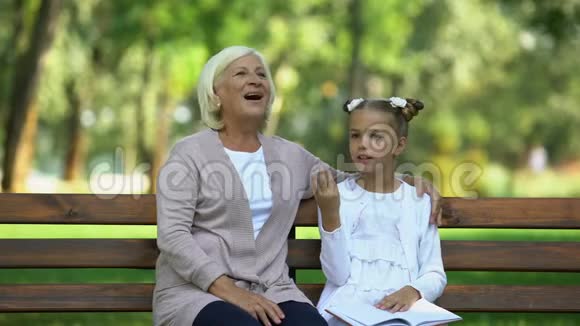 漂亮的奶奶抱着小孙女听她的故事女人的八卦视频的预览图