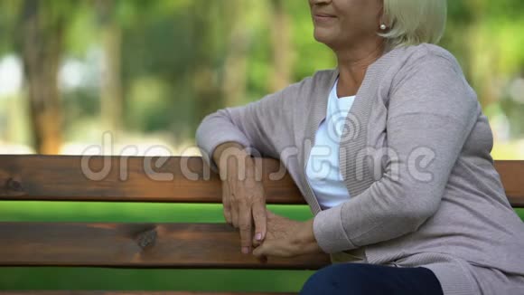 微笑成熟的女士坐在公园里对自己的生活满意养老改革视频的预览图